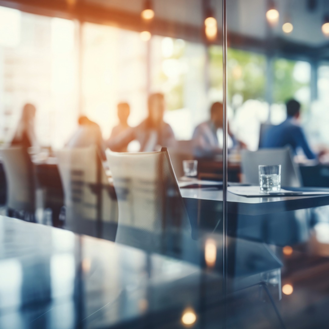 Boardroom with natural light and professionals meeting around a table, symbolizing collaboration and strategic planning.