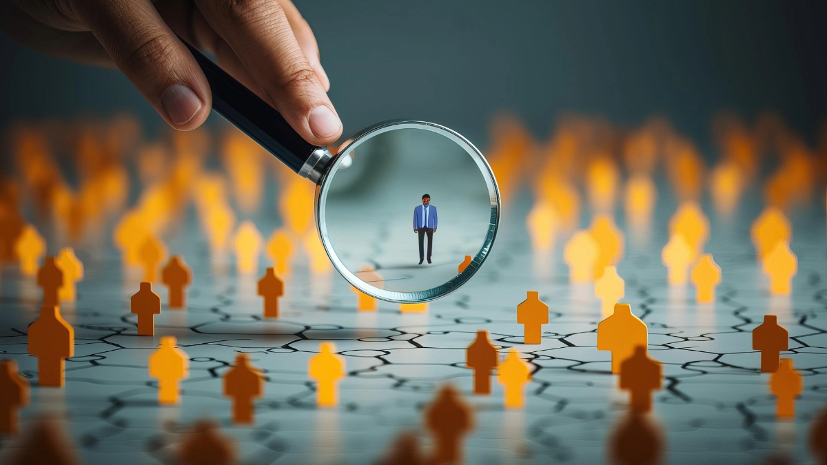 Close-up of a magnifying glass focusing on a single person among many, symbolizing member-centered strategy and focus.