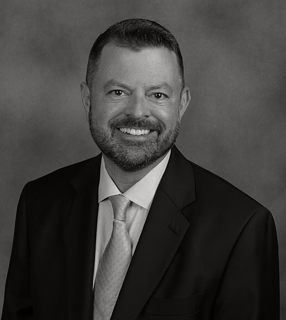 Adam Ferguson professional headshot in black and white, smiling in suit and tie