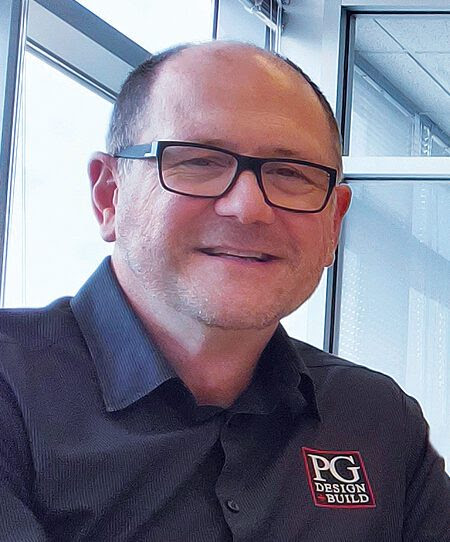 Steve Howlett, President of PG Design + Build, professional headshot wearing black shirt and glasses